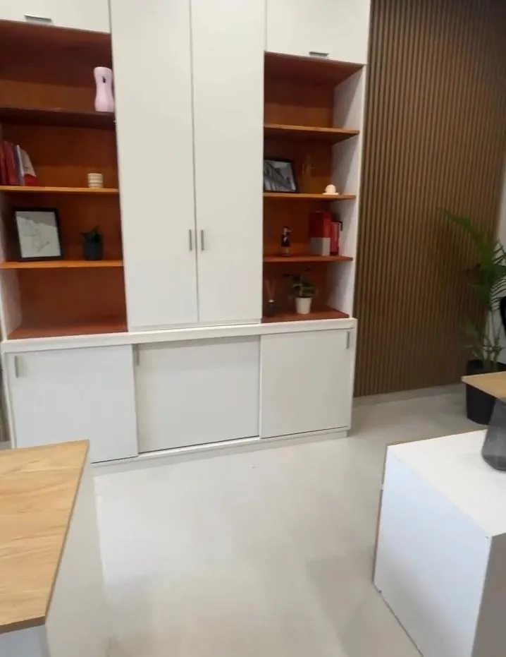 Después: biblioteca a medida blanca con estantes de madera y panel de listones